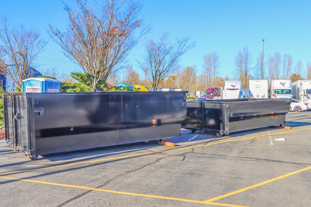 Professional dumpster rental service with roll-off container on residential driveway in Granby